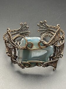 Beautiful blue banded solar agate with a sparkling druzy heart that has been hand-wrapped within a statement cuff bracelet