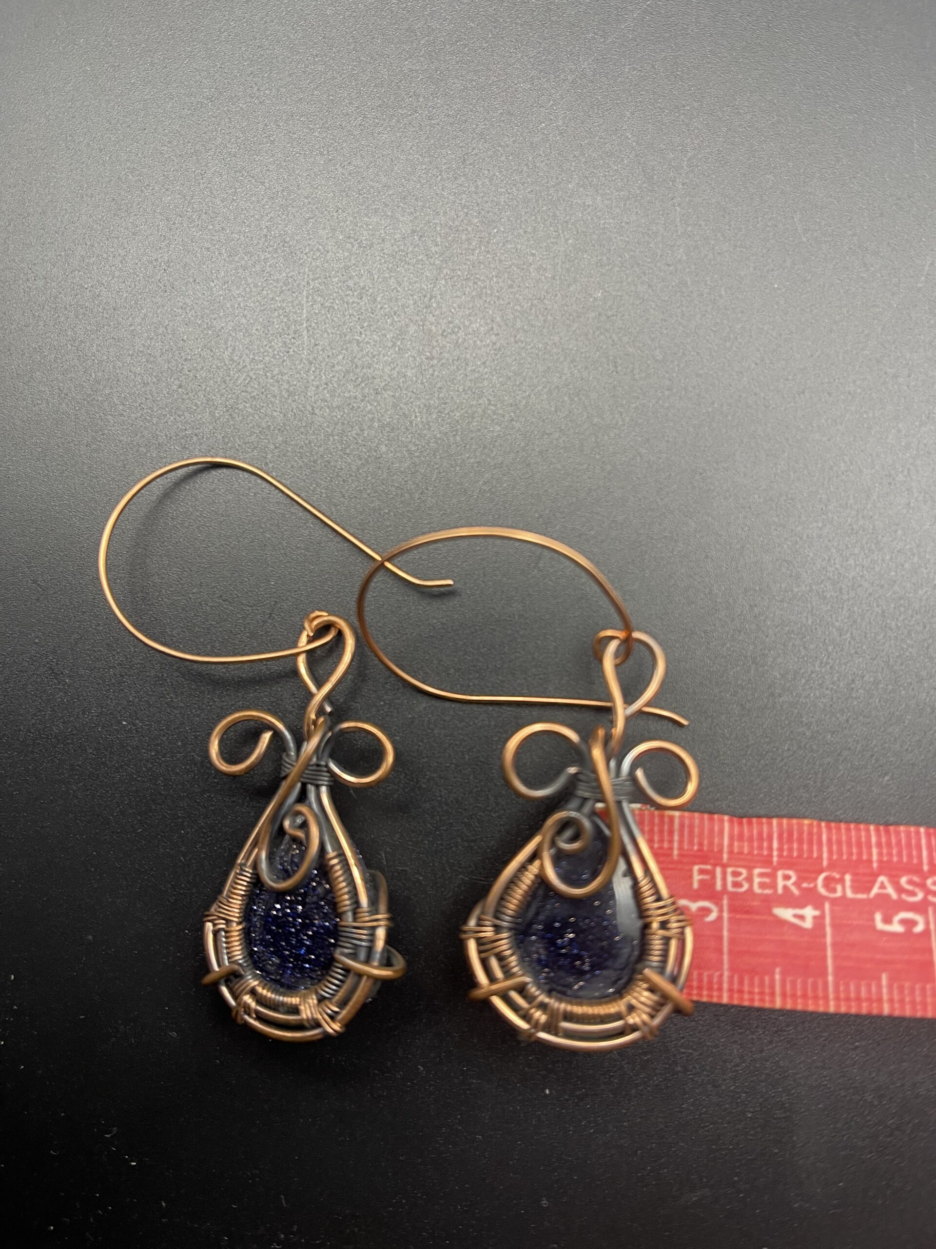 Hand Wrapped Copper Wire Earrings with Blue Goldstone 4 Blue Goldstone Setting Width Approx 2.5cms 1 inch scaled - Hand Wrapped Copper Wire Earrings with Blue Goldstone, 4, Blue Goldstone Setting Width Approx 2.5cms (1 inch) - Hand Wrapped Copper Wire Earrings with Blue Goldstone, 4, Blue Goldstone Setting Width Approx 2.5cms (1 inch) - AURORA ARTISAN JEWELLERY