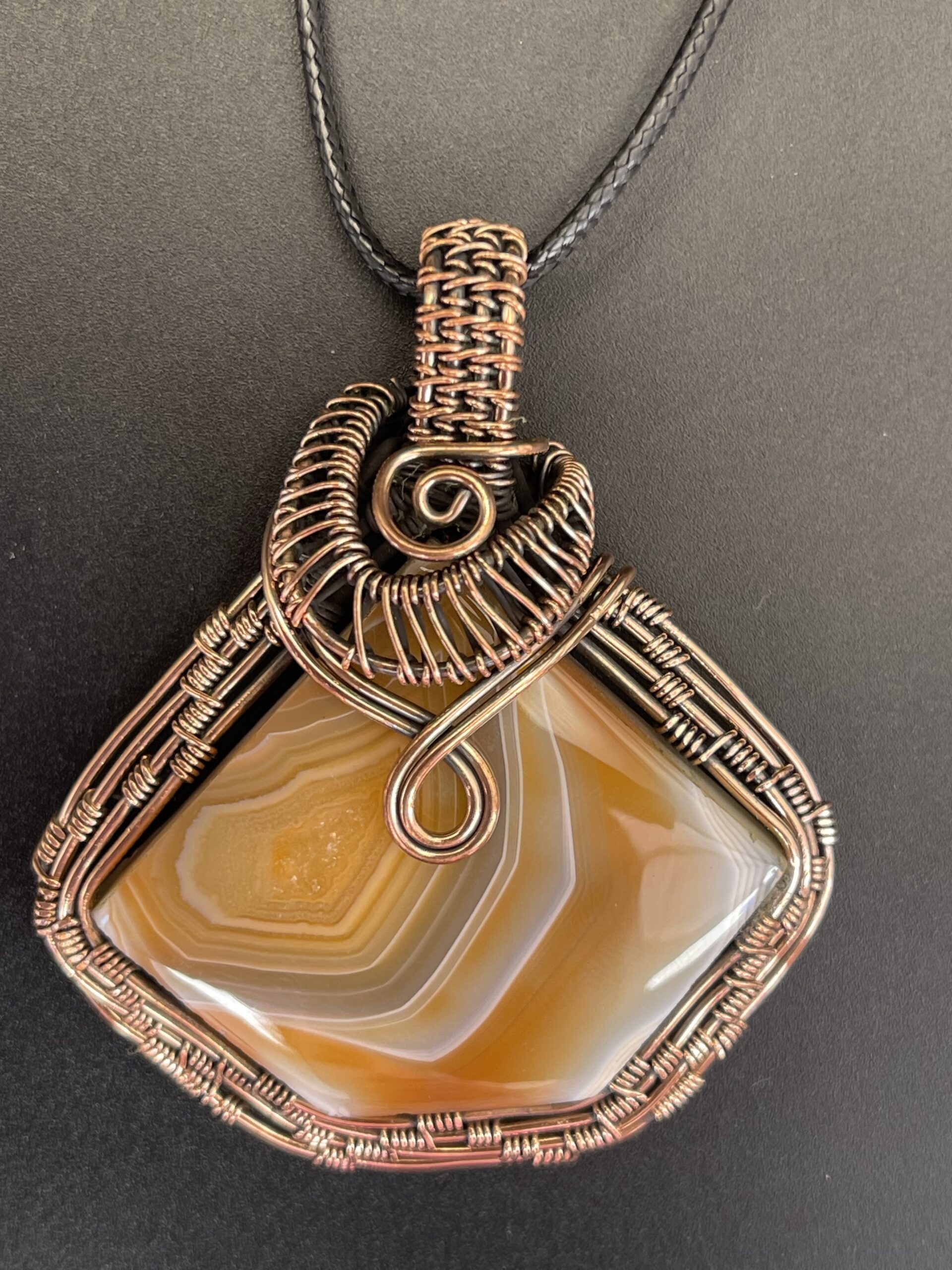 Hand-wrapped copper wire pendant featuring solar agate with beautiful banding radiating from a sparkling pocket of druzy.