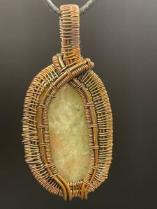 Aqua seraphinite oval cabochon set within an elegant hand-wrapped copper wire pendant.