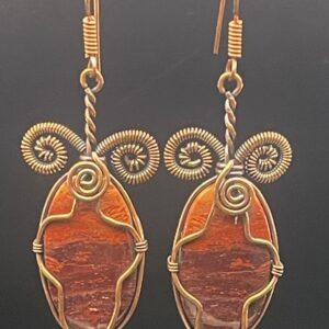 Red rainbow jasper with striking colours and metallic banding within hand-wrapped copper wire earrings featuring intricate spirals